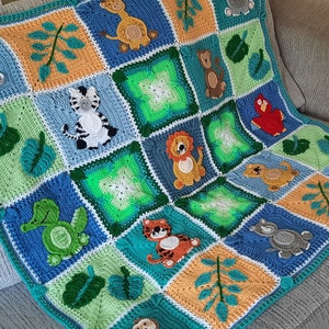 May include: A crocheted baby blanket with a jungle animal theme. The blanket features a variety of animals, including a zebra, a lion, a turtle, a monkey, and a bird. The blanket is made with a variety of colors, including green, blue, orange, and yellow.