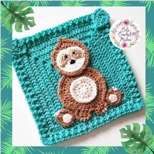 May include: A crocheted square with a brown sloth design. The sloth is sitting on a teal background. The square has a white border.