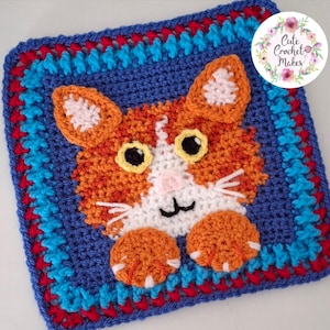 May include: A square crochet granny square featuring an orange and white cat face with yellow eyes, a pink nose, and two orange paws. The border is composed of blue, red, and light blue yarn. A circular logo in the corner reads Cute Crochet Makes.
