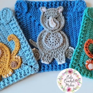 May include: Three crocheted squares featuring animal designs. The first square is blue with a yellow cat, the second is blue with a gray rhinoceros, and the third is green with an orange tiger.