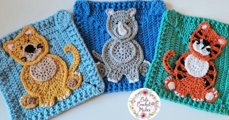 May include: Three crocheted squares featuring animal designs. The first square is blue with a yellow cat, the second is blue with a gray rhinoceros, and the third is green with an orange tiger.