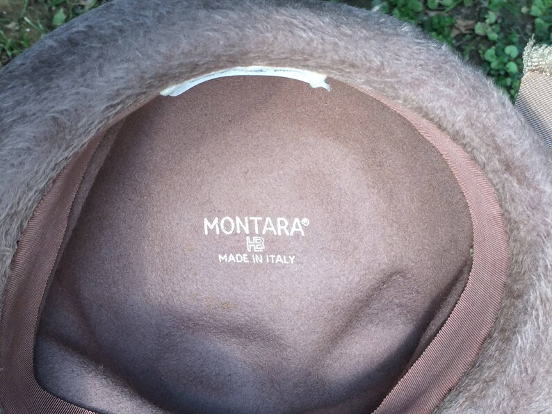 May include: The inside of a brown felt hat with a white label that reads "MONTARA&reg;" and "MADE IN ITALY".