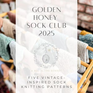 May include: A close-up of a sign that reads "Golden Honey Sock Club 2025" with a beehive illustration and the text "A Bee in the Bonnet". The sign is in front of a wooden drying rack with colorful knitted socks hanging on it.