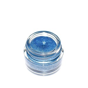 Pu&ograve; includere: Un piccolo barattolo rotondo di ombretto blu glitterato.