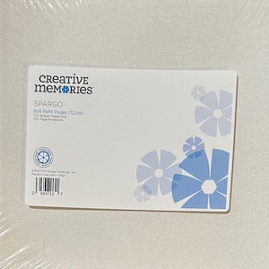 May include: A package of Creative Memories SPARGO 8x8 refill pages. The white label features blue floral designs and product information, including the number of pages and protectors. Made in the USA.