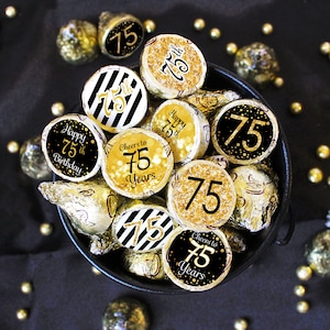 May include: Gold and black 75th birthday party favor stickers. The stickers feature a variety of designs, including a black and white striped design, a gold glitter design, and a gold and black confetti design. The stickers are perfect for adding a touch of sparkle to your party favors.
