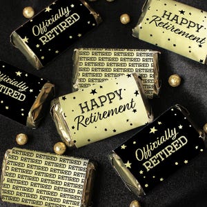 May include: A set of six gold and black chocolate bar wrappers with the text "Officially Retired" and "Happy Retirement" printed on them. The wrappers are decorated with gold stars.