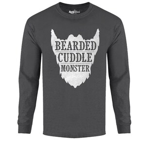 May include: A dark grey long-sleeved t-shirt with a white graphic of a beard and the text "Bearded Cuddle Monster".
