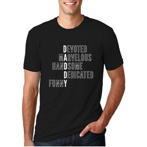 以下が含まれることがあります： 白い文字で「DAD」と書かれた黒いTシャツ。文字は「Devoted、Awesome、Dedicated、Funny」という単語で綴られています。