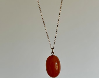 Può includere: Una collana con catena d'oro con un ciondolo di ambra di forma ovale.