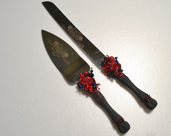 Könnte beinhalten: Ein Set aus zwei Tortenmessern mit schwarzen Griffen, die mit roten und blauen Blumen und Perlen verziert sind. Die Messer sind mit den Worten "Mr. & Mrs." und "Happily Ever After" graviert.