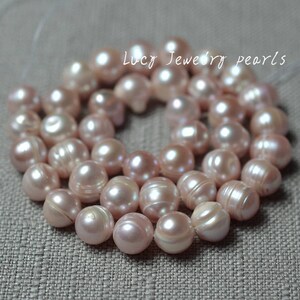 May include: A strand of pink freshwater pearls, strung together for jewellery making. The pearls are a soft, pale pink colour and have a slightly iridescent sheen.
