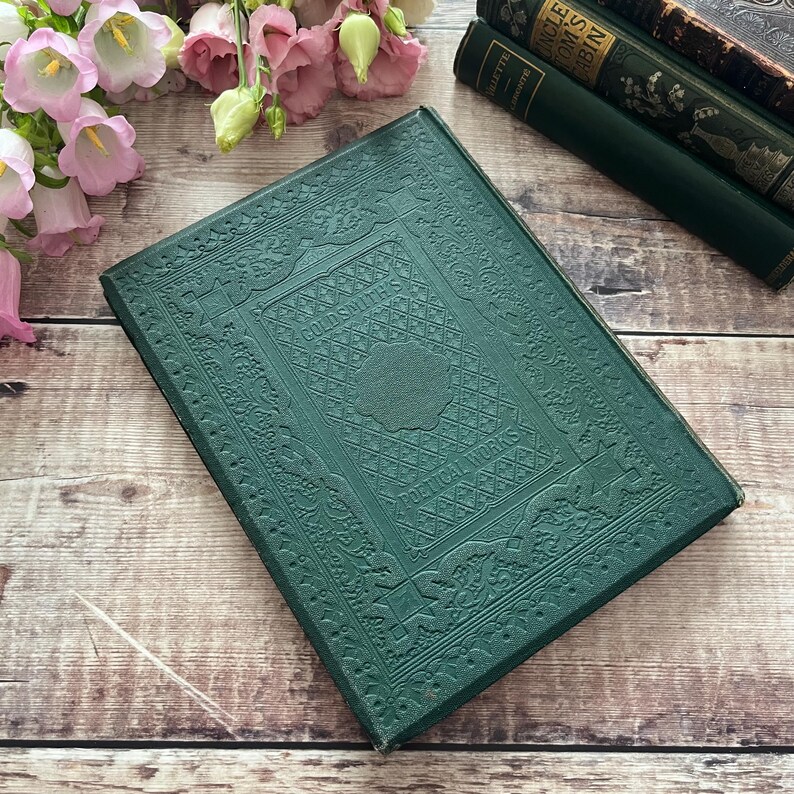 May include: A dark green hardback book with an embossed design. The title "COLUMBUS'S  DISCOVERIES" is visible on the front cover.