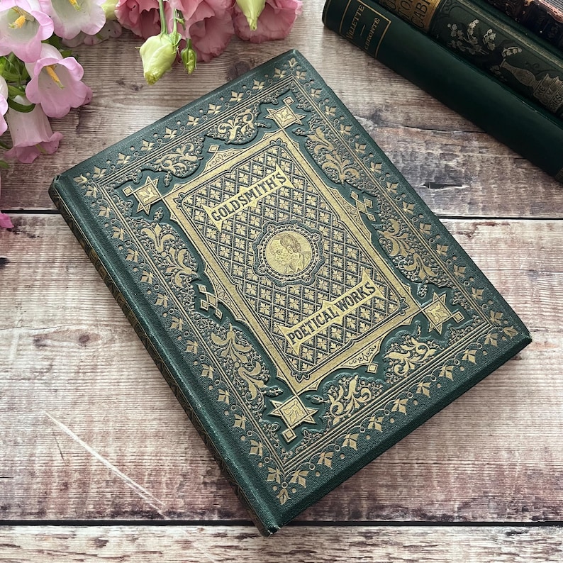 May include: A green hardback book with gold embossed lettering and intricate designs. The title reads "Goldsmith's Poetical Works".