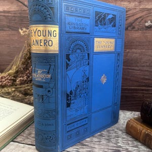 May include: A blue hardcover book, "The Young Llanero" by W.H.G. Kingston, from "The Kingston Library". The cover features gold lettering and illustrations of sailing ships. The book is marked "For Boys".