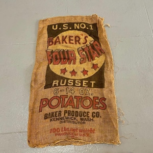 May include: Vintage burlap potato sack with the text "U.S. No. 1 Baker's Four Star Russet Potatoes." The sack is tan with brown and red lettering. It reads "6-14 oz." and "100 lbs. net weight."