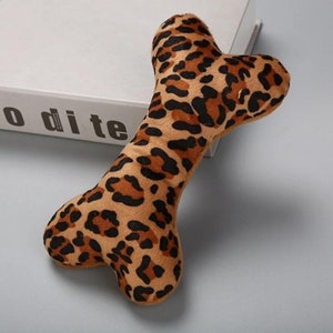 May include: A brown and black leopard print plush dog bone toy.