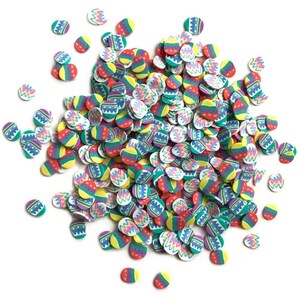 May include: A large pile of colorful Easter egg-shaped sprinkles. The sprinkles are white with different colored designs, including pink, blue, green, yellow, and red.