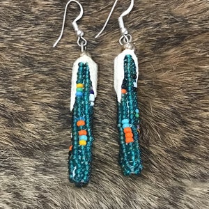May include: A pair of turquoise and white beaded earrings with silver hooks. The beads are arranged in a cascading pattern.