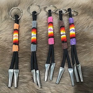 May include: Five beaded keyrings with black cords and silver tips. The beads are in various colours, including orange, red, yellow, white, pink, purple, brown, and black.