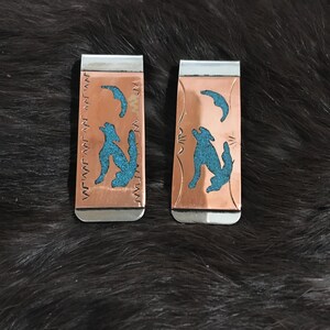 May include: Two silver and copper money clips with a turquoise inlay of a wolf design.
