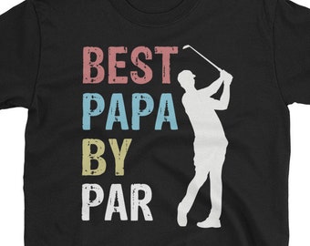 May include: Black t-shirt with the text "BEST PAPA BY PAR" in a distressed, multi-colored font. A white silhouette of a golfer swinging a club is on the right side of the shirt. The shirt is made of a soft material.