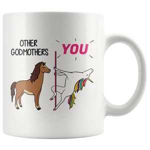 Puede incluir: Taza de café de cerámica blanca con una ilustración humorística que compara a otras madrinas con un caballo y a la destinataria con un unicornio haciendo un baile de barra. El texto dice "Otras madrinas" y "Tú".