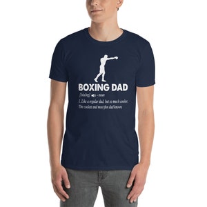 May include: Navy blue t-shirt with the text "BOXING DAD" and a definition. The definition includes the word "cooler" and a silhouette of a boxer. A great gift for a boxing enthusiast.