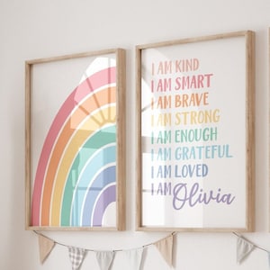 May include: Two framed prints featuring a rainbow design and positive affirmations. The left print shows a rainbow with a sun in the centre. The right print has the text "I am kind, I am smart, I am brave, I am strong, I am enough, I am grateful, I am loved, I am Olivia".