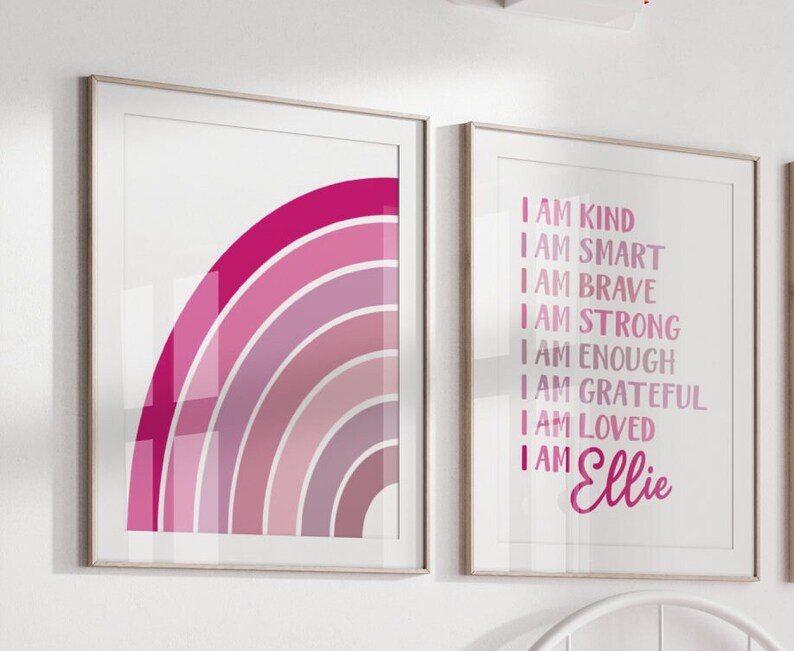 May include: Two framed prints with a pink and purple rainbow design on the left and a white background with pink text on the right. The text reads "I am kind, I am smart, I am brave, I am strong, I am enough, I am grateful, I am loved, I am Ellie".