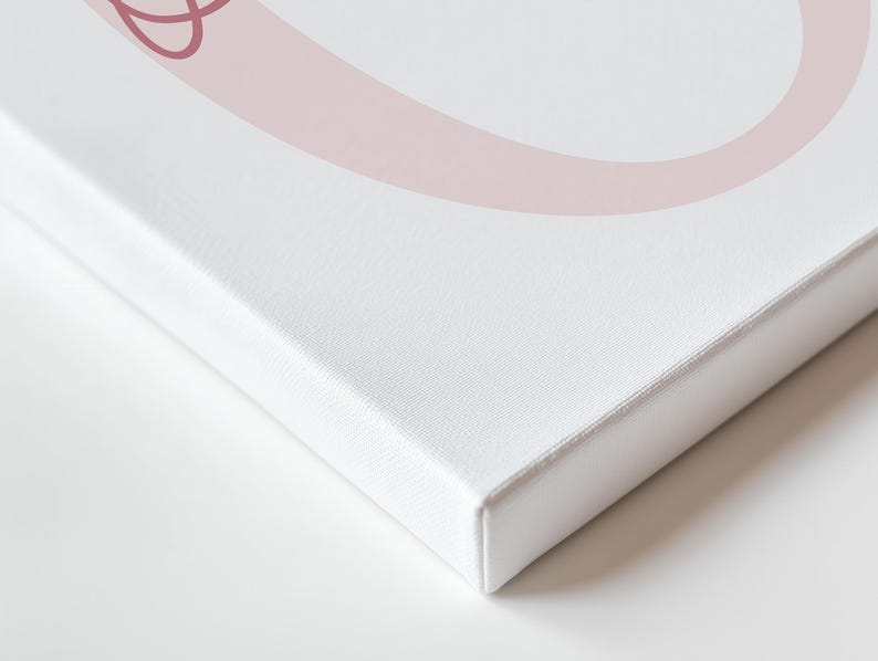 May include: A white canvas print with a light pink abstract design. The canvas is stretched over a wooden frame, with a clean, crisp edge. The artwork is displayed on a white surface, creating a minimalist aesthetic.