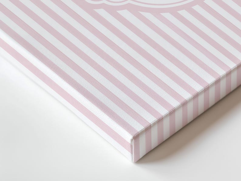 May include: A canvas print featuring a diagonal pattern of pink and white stripes. The edges of the canvas reveal the wooden frame. The print is a close-up shot, highlighting the texture and design.