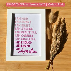 May include: A white 5x7 inch frame with a pink print that reads "I am kind, I am smart, I am brave, I am strong, I am beautiful, I am capable, I am grateful, I am enough, I am loved, I am Amelia".