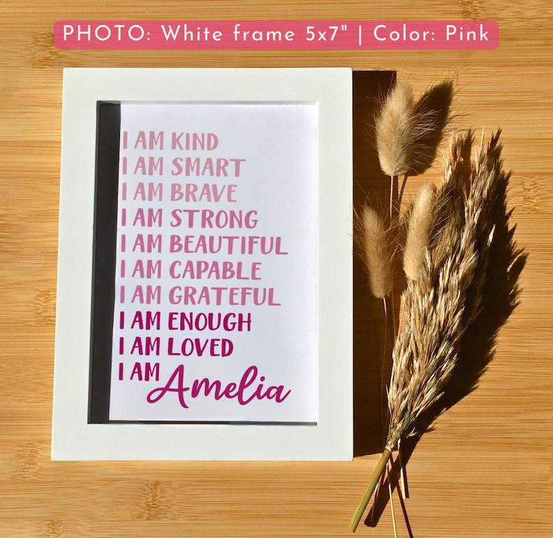May include: A white 5x7 inch frame with a pink print that reads "I am kind, I am smart, I am brave, I am strong, I am beautiful, I am capable, I am grateful, I am enough, I am loved, I am Amelia".