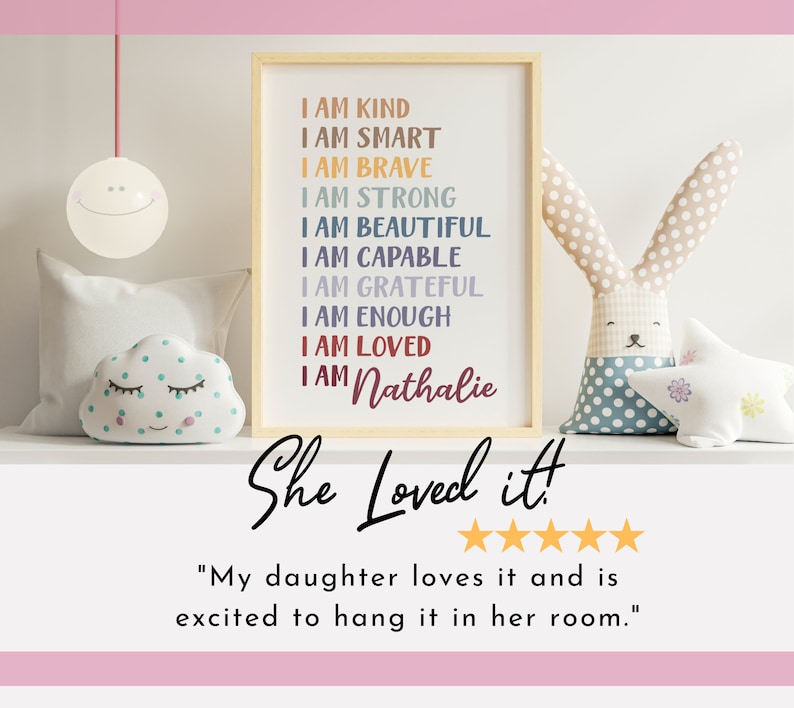 May include: A framed print with the text "I am kind, I am smart, I am brave, I am strong, I am beautiful, I am capable, I am grateful, I am enough, I am loved, I am Nathalie" in colorful text. The print is on a shelf with a white cloud-shaped stuffed toy, a white star-shaped stuffed toy, and a gray and white bunny-shaped stuffed toy.