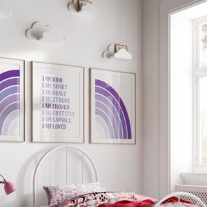May include: Three framed prints with purple and white rainbow designs. The center print has the text "I am kind, I am smart, I am brave, I am strong, I am enough, I am grateful, I am capable, I am loved".