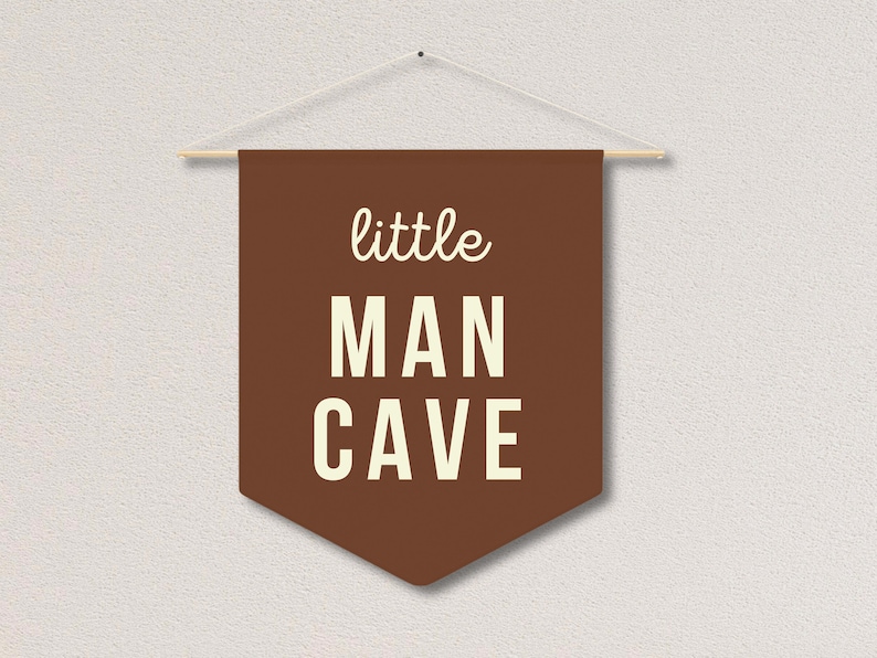 Peut inclure: Banni&egrave;re en feutre marron avec du texte blanc qui dit "little man cave".