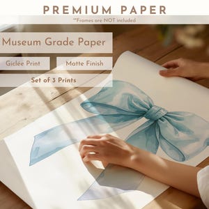 May include: A set of three prints on museum grade paper with a gicl&eacute;e print and matte finish. The prints feature a watercolor illustration of a light blue bow.