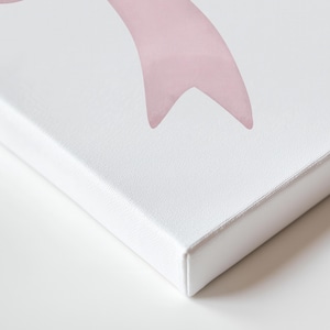 Puede incluir: Impresi&oacute;n en lienzo blanco con un dise&ntilde;o de lazo rosa estilo acuarela. El lienzo est&aacute; estirado sobre un marco de madera, con los bordes visibles. La obra de arte tiene una est&eacute;tica suave y femenina.