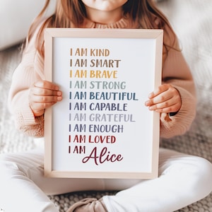 May include: A framed print with a white background and colorful text that reads "I am kind, I am smart, I am brave, I am strong, I am beautiful, I am capable, I am grateful, I am enough, I am loved, I am Alice".
