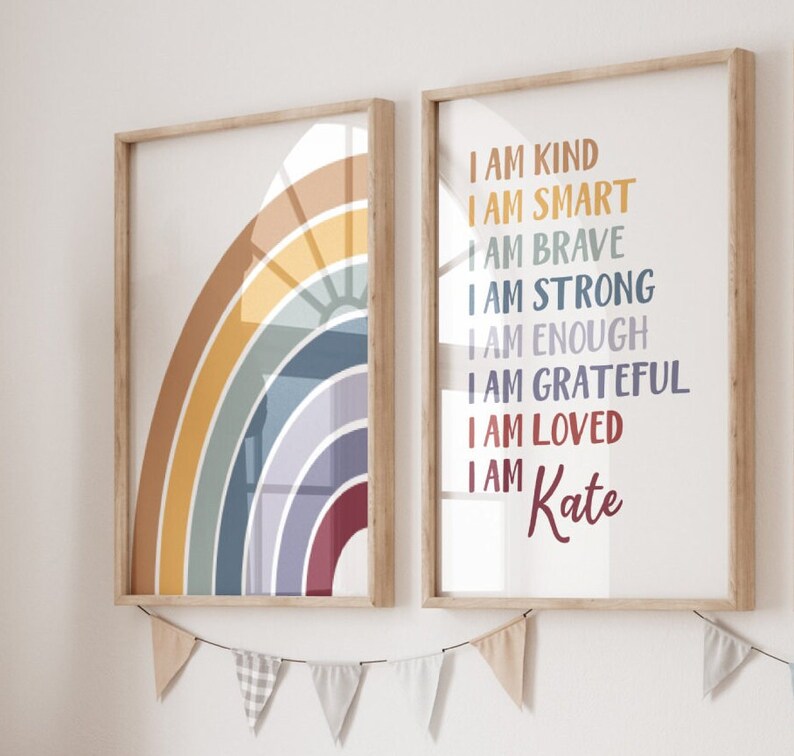 May include: Two framed prints featuring a rainbow design and a list of positive affirmations. The rainbow print has a yellow, orange, red, blue, and purple colour scheme. The affirmation print has the text "I am kind, I am smart, I am brave, I am strong, I am enough, I am grateful, I am loved, I am Kate".
