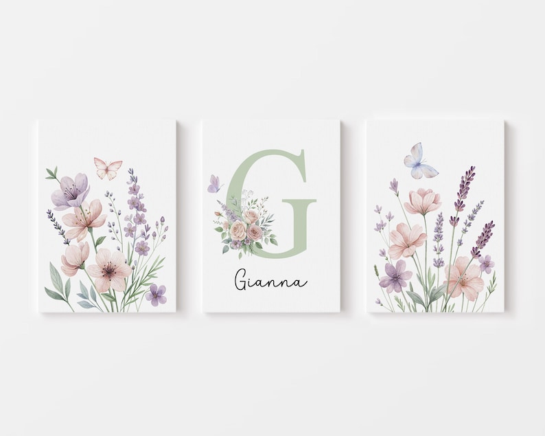 May include: Three framed floral art prints. Each print features watercolor flowers in pink, purple, and white, with butterflies. The center print has a large green letter "G" and the name "Gianna".