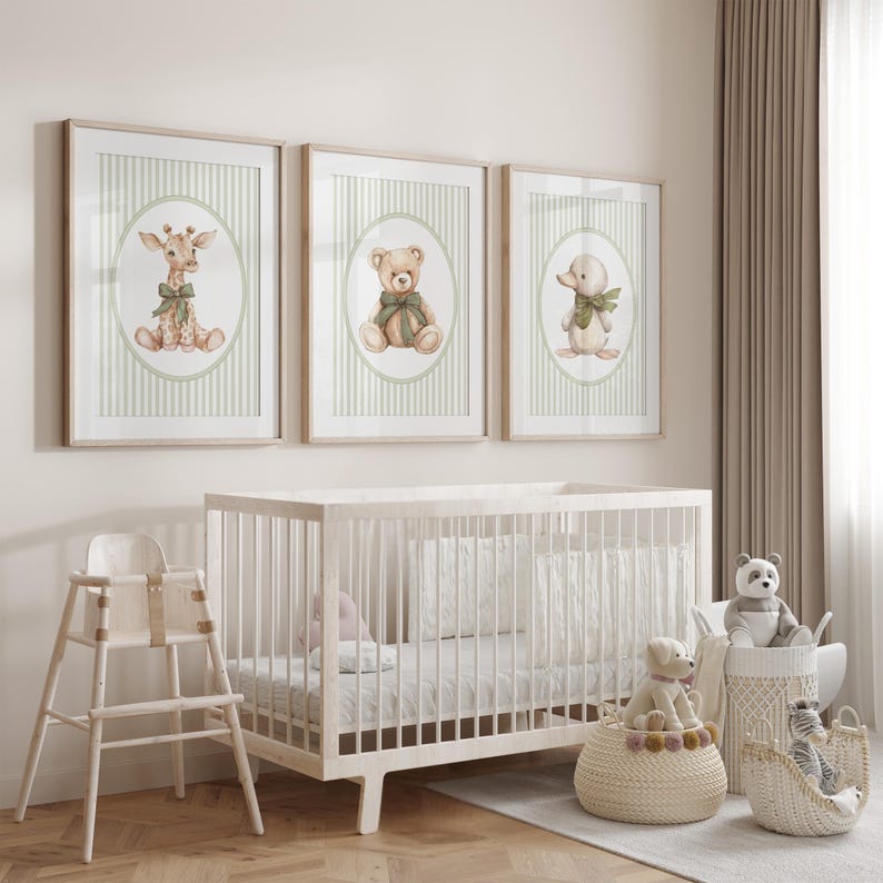 May include: Three framed nursery art prints with a giraffe, teddy bear, and duck, each with a green bow, on a striped background. A white cot, high chair, and baskets with soft toys complete the nursery scene.