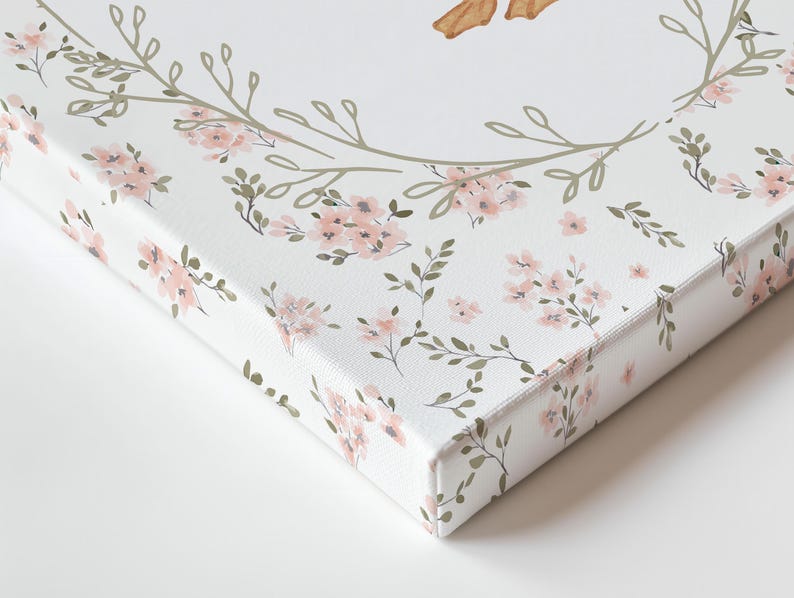 May include: Close-up of a canvas print featuring a floral design. The print has a white background with a pattern of pink flowers and green leaves. The edges of the canvas are also printed with the floral pattern.