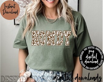 May include: A green t-shirt with the word "HOWDY" in brown and white cow print letters.