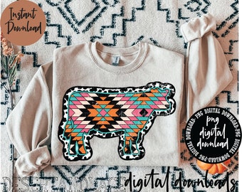 May include: A digital download of a cow graphic with a geometric pattern in pink, orange, blue, and black. The cow is outlined in black with white spots. The graphic is on a beige sweatshirt.