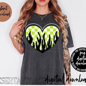 May include: Dark gray t-shirt featuring a heart design with a green and white checkered pattern and black flames. The shirt has the words "Instant Download" and "PNG digital download" on it. The text "DESERTANDLACE digital downloads" is also visible.