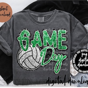 Könnte beinhalten: Graues T-Shirt mit einem Volleyball-Motiv und den Worten "GAME DAY" in grünem Glitzer. Das Shirt hat auch die Aufschrift "Sofort-Download" und "digitale Downloads". Das Shirt ist gefaltet.
