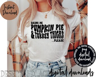 May include: A white t-shirt with black text that reads "Bring me pumpkin pie & turkey thighs... please". The shirt is being worn by a person with long blonde hair and is paired with blue jeans.