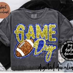 Könnte beinhalten: Graues T-Shirt mit dem Schriftzug "GAME DAY" in goldfarbenem Glitzer und einer braunen Football-Grafik. Das Shirt trägt auch die Texte "Sofort-Download" und "digitale Downloads".